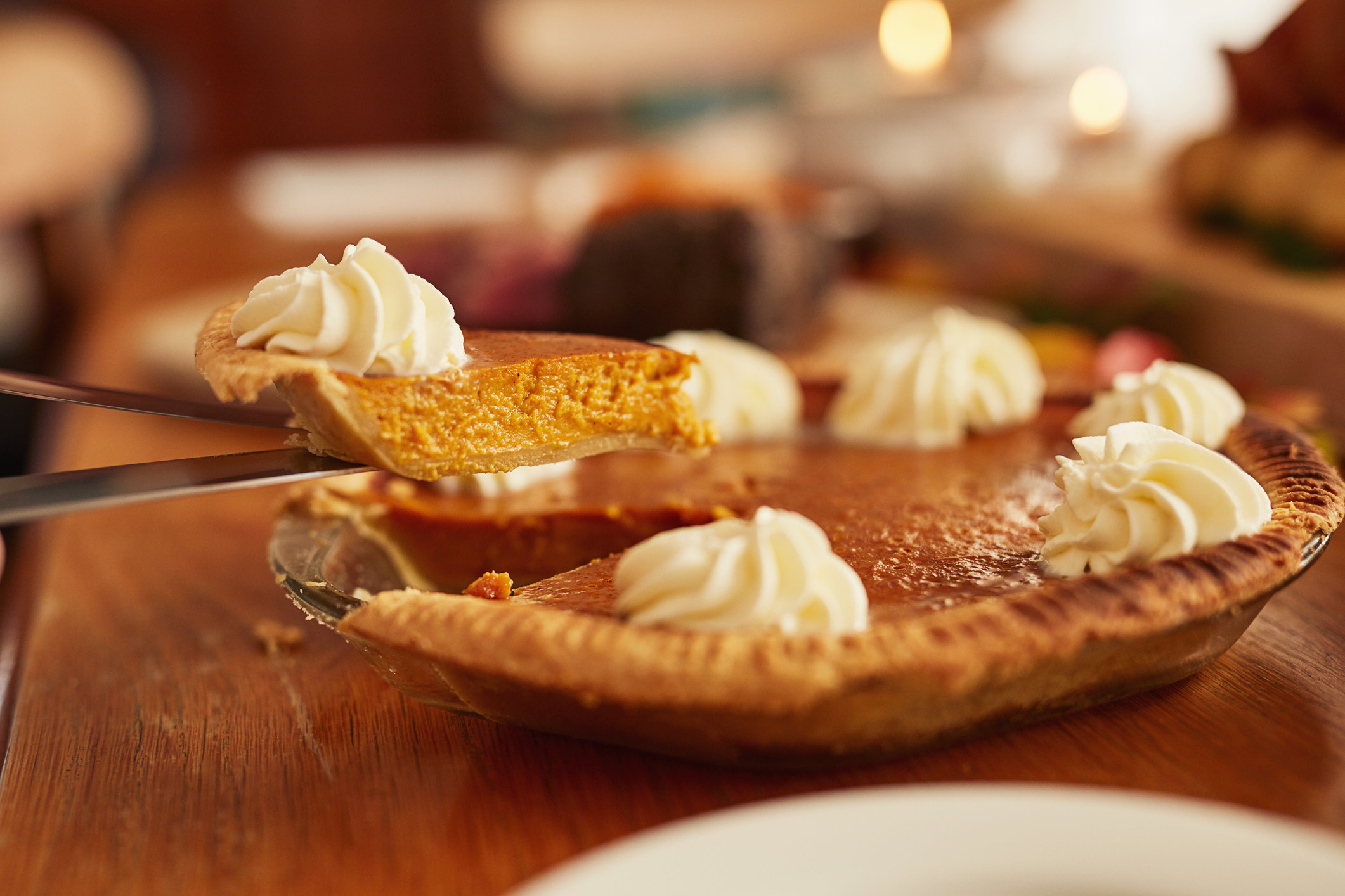 A person slicing pumpkin pie